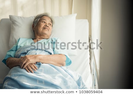 Сток-фото: Old And Lonely Lady Looking Outside Through Her Window