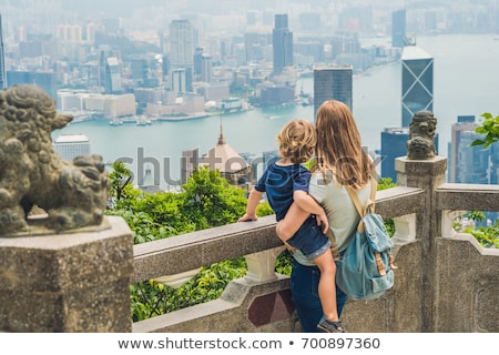 Foto stock: Mom And Son Travelers At The Peak Of Victoria Against The Backdrop Of Hong Kong Traveling With Chil