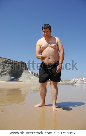 Foto stock: Fat Man Playing Beach Tennis On The Beach