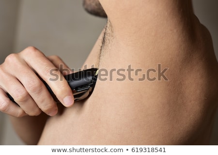 ストックフォト: Man Trimming His Armpit With An Electric Trimmer