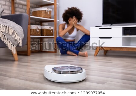 Stok fotoğraf: Weighing Scale In Front Of Crying Young Woman On Floor