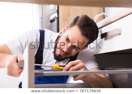 Zdjęcia stock: Carpenter Fixing Drawer In Kitchen