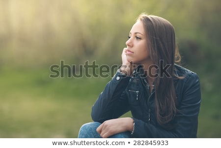 Foto d'archivio: Smiling Young Brunette Girl Resting And Sitting On Green Grass A