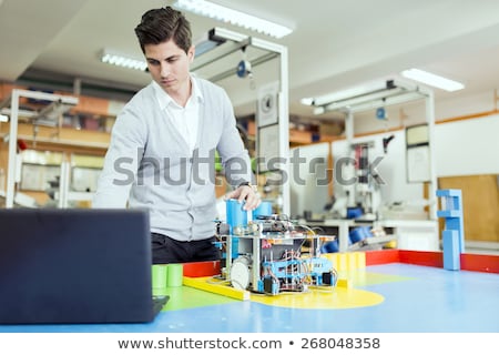 Foto stock: Electrical Engineer Programming A Robot During Robotics Class