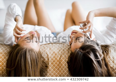 Foto stock: Two Stunning Women Talking On Phones With Their Hair Falling Off