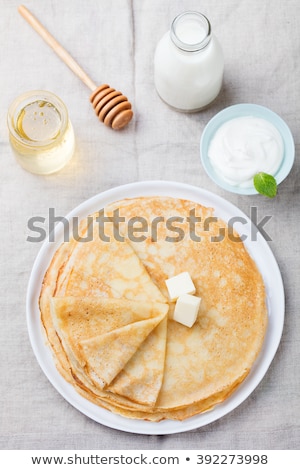 Stock fotó: Thin Crepes Or Pancakes With Butter Honey And Sour Cream On A Rustic Textile Background