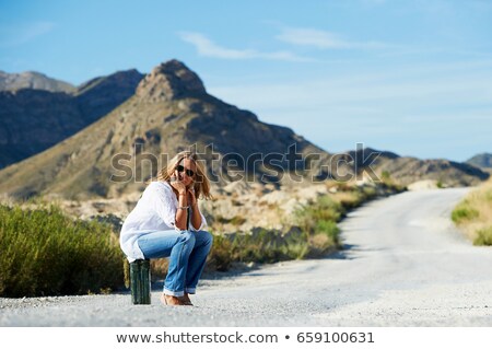 Stock photo: Woman Sitting On Petrol Can In The Road