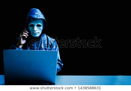 Foto stock: Hacker With Laptop Calling On Cellphone