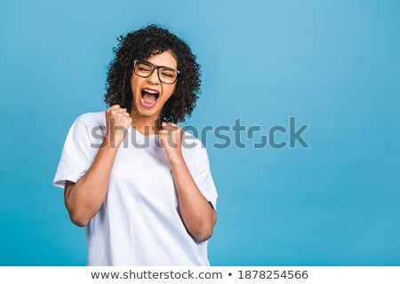 [[stock_photo]]: Cute Pretty Woman Showing Winner Gesture Isolated Over Blue Wall Background