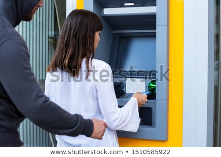 Foto stock: Robber Snatching Card From Womans Hand Using Atm