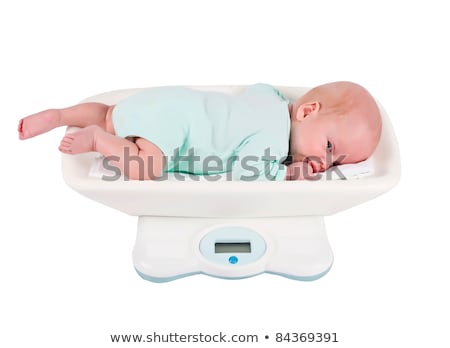 Stock photo: Baby Girl On On Weighing Scale