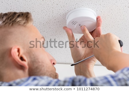 Foto d'archivio: Handyman Installing Smoke Detector