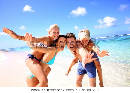 ストックフォト: Group Of Young Happy People Carrying Women On A Sandy Beach