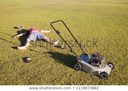 Imagine de stoc: Man Mowing A Lawn