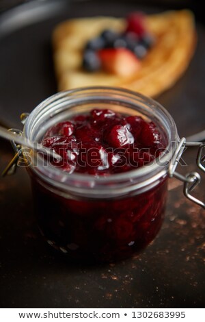 Foto stock: Close Up On Jar Filled With Fresh Cherry Marmalade Placed On Dark Rusty Table
