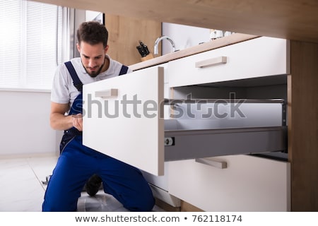 Stok fotoğraf: Handyman Fixing Drawer In Cabinet