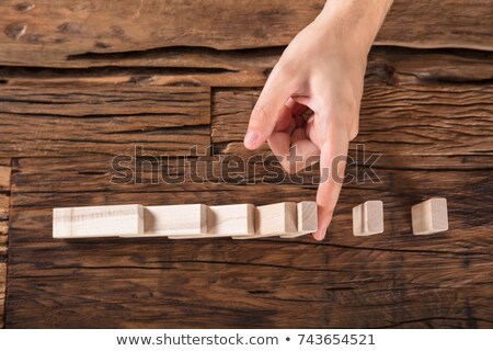 Stock fotó: Person Stopping Dominoes To Continue Toppled At Desk