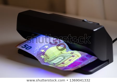 Foto stock: Banknote And Banknote Detector Machine On Desk