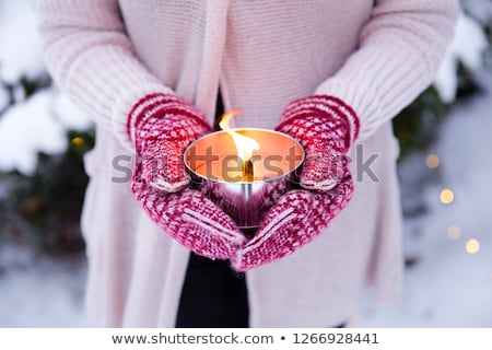 Stock fotó: Close Up Of Hands In Winter Mittens Holding Candle