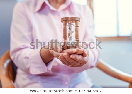 Stock fotó: Senior In Nursing Home Holding A Hourglass - Time Is Running Up