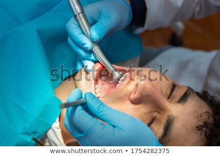Stockfoto: Dentist Doing Procedure At Dental Curing Clinic