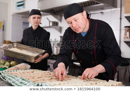 [[stock_photo]]: Man Preparing Meat Stuffed Cannelloni