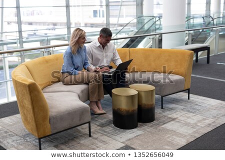 Stock fotó: Side View Of Caucasians Business Executives Using Laptop Sitting On The Sofa In Modern Office