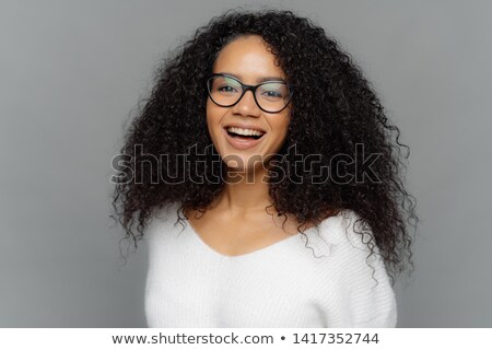 Stock photo: Candid Shot Of Optimistic Curly Woman Laughs Positively Being In Good Mood Has Healthy Skin Looks