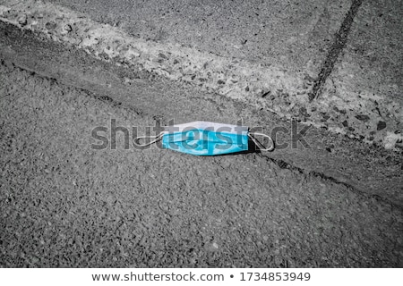 Zdjęcia stock: Used Surgical Mask Thrown On The Asphalt