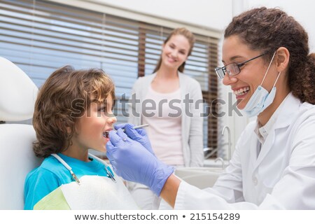 [[stock_photo]]: Pediatric Dentist Smiling With Little Boy In Chair