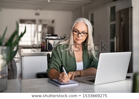 Stock fotó: Senior Woman Writing To Notebook Or Diary At Home