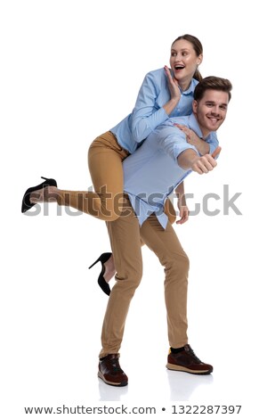 Foto d'archivio: Excited Woman Looking Surprisd While Being Carried By Young Man