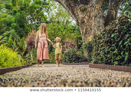 ストックフォト: Mother And Son Walking On A Textured Cobble Pavement Reflexology Pebble Stones On The Pavement For