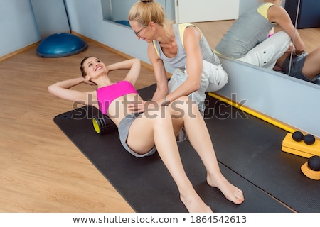 Foto d'archivio: Woman With Physical Therapist Doing Fascial Training With Roll