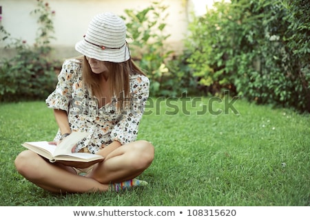 Foto stock: Beautiful Caucasian Woman Reading A Book At The Park