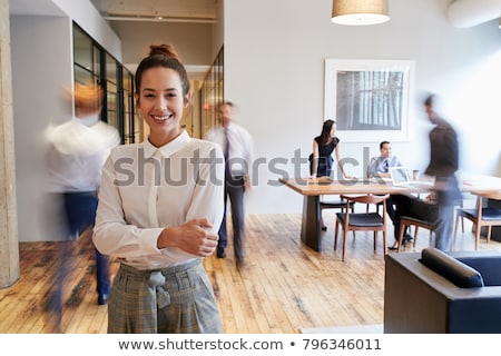 Stockfoto: Young Woman In A Busy Office