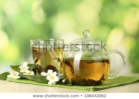 [[stock_photo]]: Green Tea With Jasmine In Cup And Teapot On Wooden Table