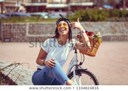 Stock foto: Young Beautiful Woman Sitting On Her Bicycle With Flowers At Sun