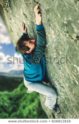 Foto stock: Man Hanging Cliff Edge