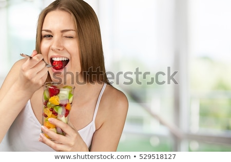 [[stock_photo]]: Portrait Of A Woman Eating Fruit Salad