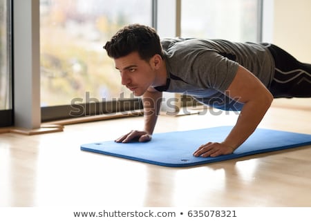 [[stock_photo]]: Man Doing Pushups In Gym