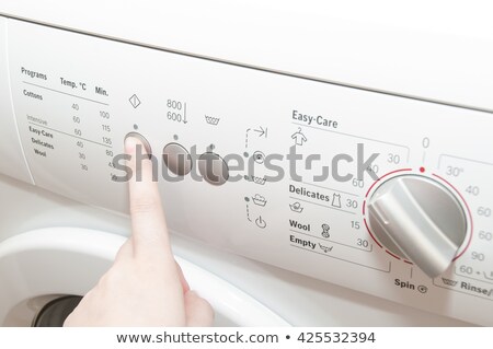 Foto stock: Woman Choosing Program For Washing