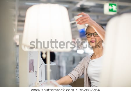 Foto stock: Pretty Young Woman Choosing The Right Light For Her Appartment