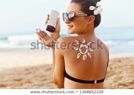 Foto d'archivio: Woman On The Beach Using Suncream