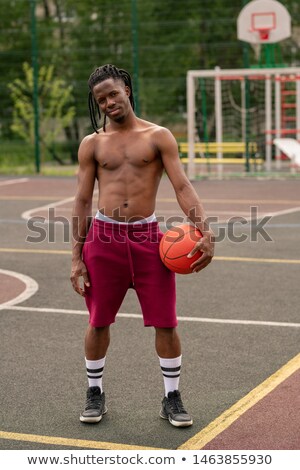 Foto stock: Shirtless African Muscular Guy With Ball Standing On Basketball Court