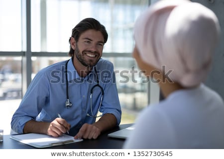 [[stock_photo]]: High View Of Pretty Disabled Young Mixed Race Woman And Handsome Caucasian Young Male Doctor Interac