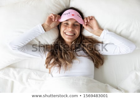 Stok fotoğraf: Portrait Of A Smiling Happy Woman Laying On The Pillow