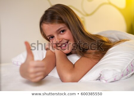 Stock foto: Young Girl Showing Thumbs Up Sign With A Grin Shallow Depth