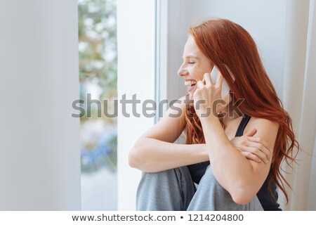 [[stock_photo]]: Woman Calling On Smartphone At Window In Morning