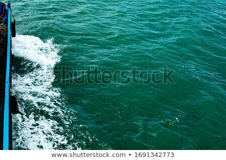 Foto stock: Wave From Boat On Water Surface Beside Island Coast